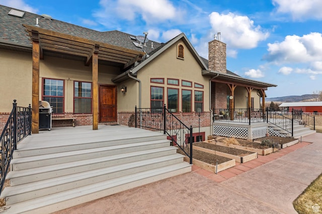 655 W 85 S, Glenwood, UT 84730 - view of front facade featuring a chimney, brick siding, stucco siding, roof with shingles, and a porch