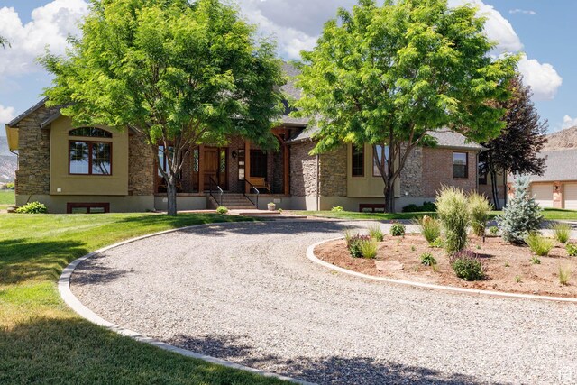 655 W 85 S, Glenwood, UT 84730 - view of front of property with curved driveway, stone siding, covered porch, a front lawn, and brick siding