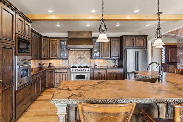 655 W 85 S, Glenwood, UT 84730 - kitchen featuring stainless steel appliances, light wood-style floors, custom exhaust hood, a breakfast bar, and recessed lighting