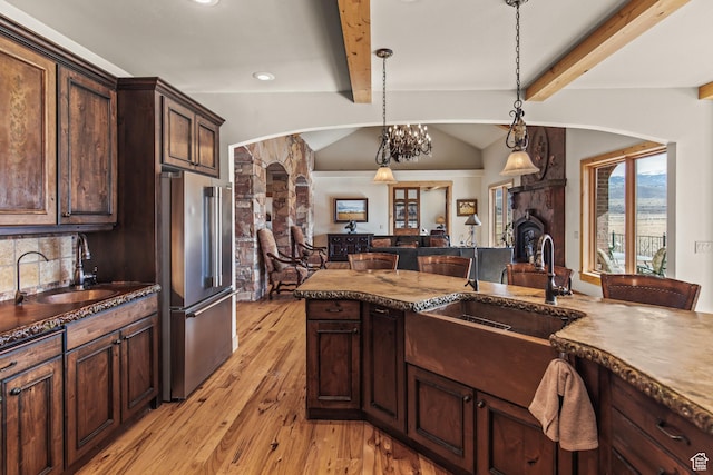 655 W 85 S, Glenwood, UT 84730 - kitchen with high end fridge, light wood finished floors, arched walkways, decorative light fixtures, and dark brown cabinets