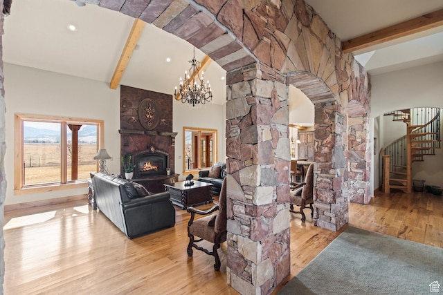 655 W 85 S, Glenwood, UT 84730 - living room featuring arched walkways, a warm lit fireplace, stairway, wood finished floors, and decorative columns