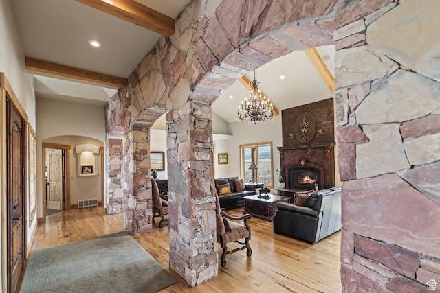 655 W 85 S, Glenwood, UT 84730 - living area featuring arched walkways, beamed ceiling, hardwood / wood-style flooring, ornate columns, and a fireplace