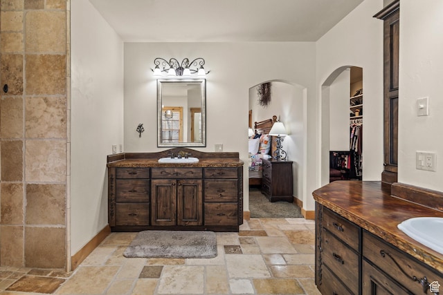 655 W 85 S, Glenwood, UT 84730 - bathroom featuring stone tile floors, two vanities, and a walk in closet