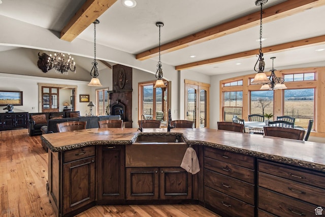655 W 85 S, Glenwood, UT 84730 - kitchen with open floor plan, light wood-style flooring, a breakfast bar, dark brown cabinetry, and pendant lighting