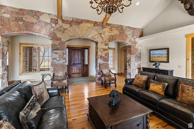 655 W 85 S, Glenwood, UT 84730 - living room with arched walkways, a chandelier, wood finished floors, high vaulted ceiling, and beamed ceiling