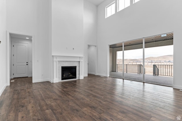 unfurnished living room featuring dark hardwood / wood-style flooring, a mountain view, and a brick fireplace