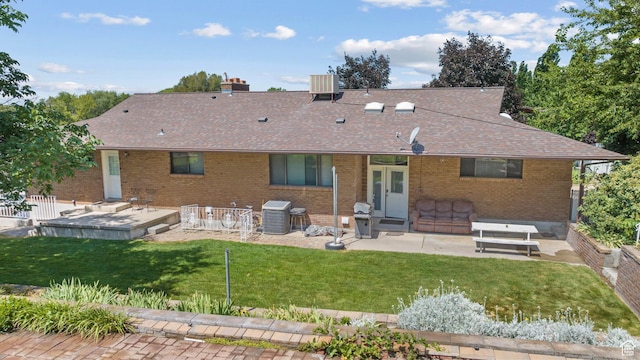 1975 Laguna Vista Dr, Orem, UT 84058 - back of house with roof with shingles, a patio area, brick siding, a yard, and a chimney