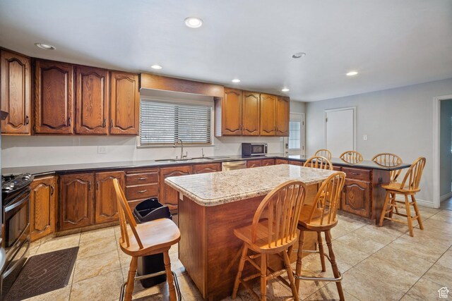 1975 Laguna Vista Dr, Orem, UT 84058 - kitchen with sink, stainless steel appliances, a center island, light stone countertops, and a kitchen bar