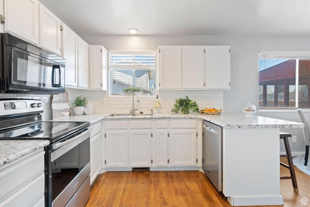 9737 S Stonehaven St, South Jordan, UT 84009 - kitchen featuring stainless steel appliances, sink, white cabinets, and kitchen peninsula