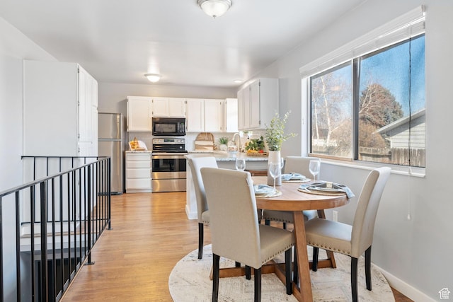 9737 S Stonehaven St, South Jordan, UT 84009 - dining room featuring a healthy amount of sunlight, sink, and light hardwood / wood-style flooring