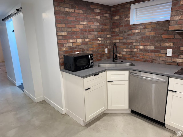 kitchen with white cabinetry, a barn door, sink, and stainless steel dishwasher