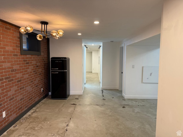 spare room featuring brick wall and concrete floors