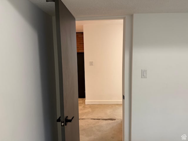 hall with a textured ceiling