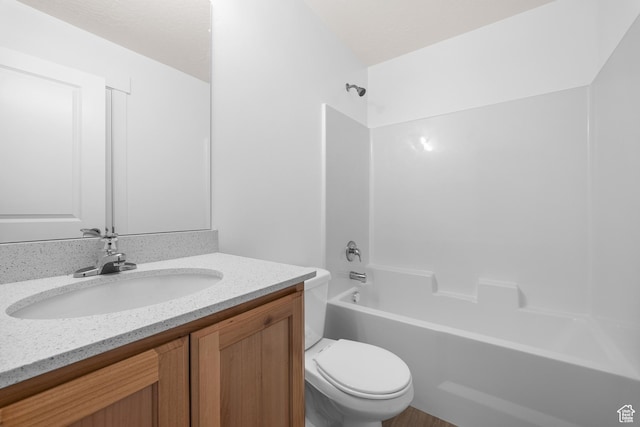 bathroom with toilet,  shower combination, and vanity