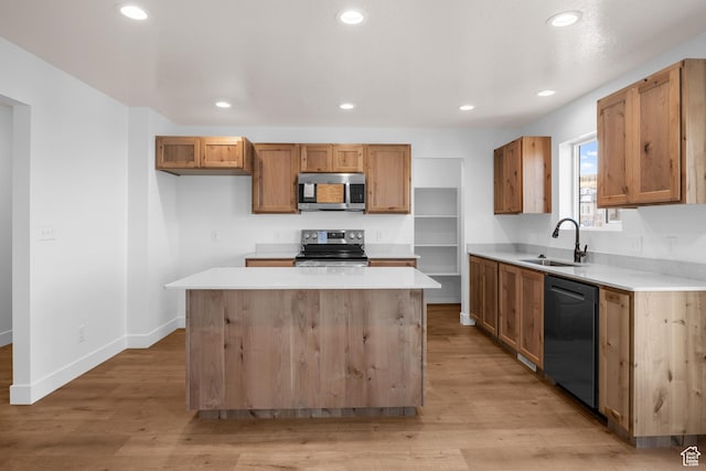 kitchen featuring a sink, stainless steel appliances, light countertops, and a center island