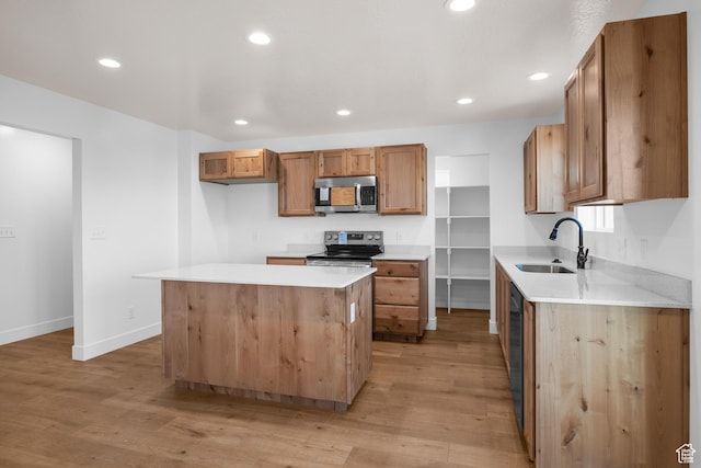 kitchen featuring light countertops, appliances with stainless steel finishes, brown cabinetry, a kitchen island, and a sink