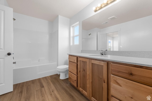 full bathroom with shower / bathtub combination, visible vents, toilet, vanity, and wood finished floors