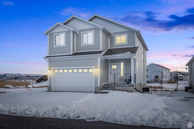 view of front of property featuring a garage and central AC unit