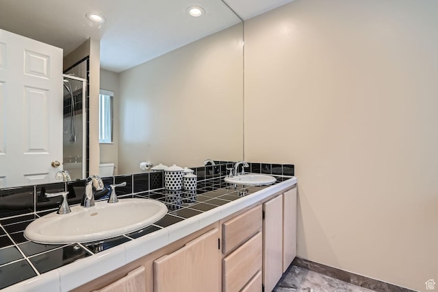 bathroom with vanity, a shower with shower door, and toilet