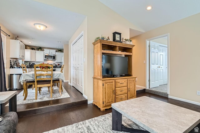 living room featuring vaulted ceiling and dark hardwood / wood-style flooring