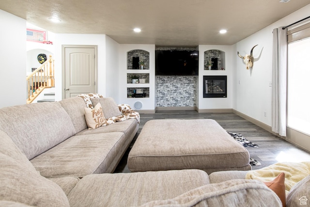living room with built in shelves and wood-type flooring