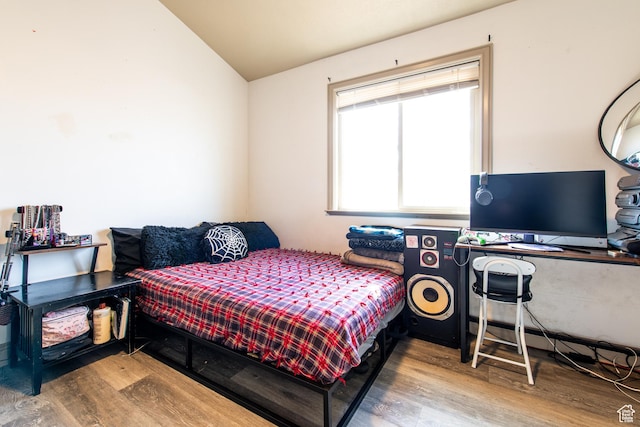 bedroom with vaulted ceiling and hardwood / wood-style floors