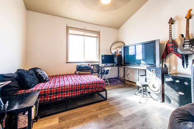 bedroom featuring hardwood / wood-style flooring and vaulted ceiling