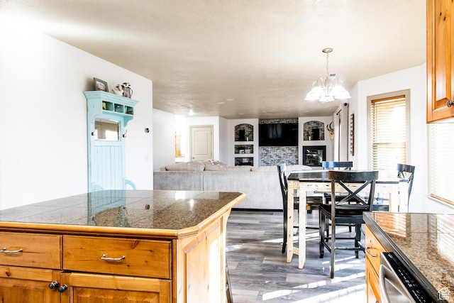 kitchen featuring hanging light fixtures, dark hardwood / wood-style flooring, dishwasher, and a chandelier