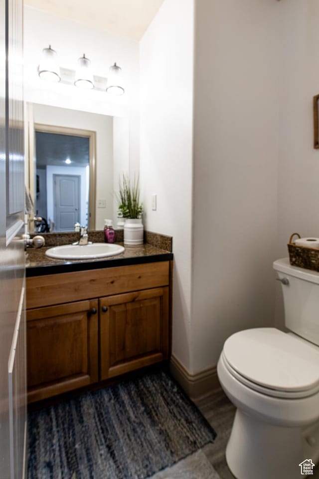 bathroom with vanity, hardwood / wood-style floors, and toilet