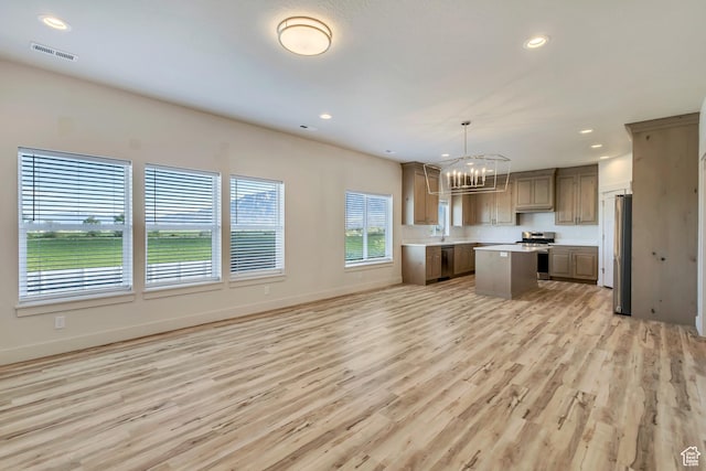 4024 W 2875 N, Plain City, UT 84404 - kitchen with stainless steel appliances, a chandelier, a kitchen island, light wood-style floors, and light countertops