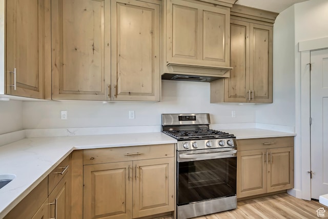 4024 W 2875 N, Plain City, UT 84404 - kitchen featuring stainless steel gas stove, premium range hood, light wood-type flooring, light brown cabinetry, and light stone counters