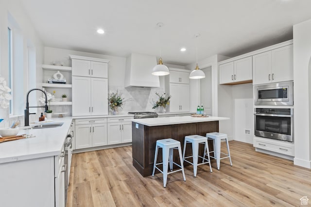 3559 S Garibaldi Way, Saratoga Springs, UT 84045 - kitchen with white cabinetry, sink, a center island, stainless steel appliances, and custom range hood