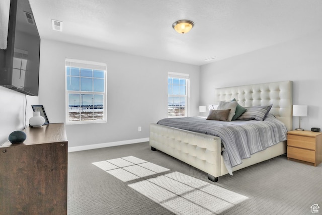 bedroom with multiple windows and dark colored carpet