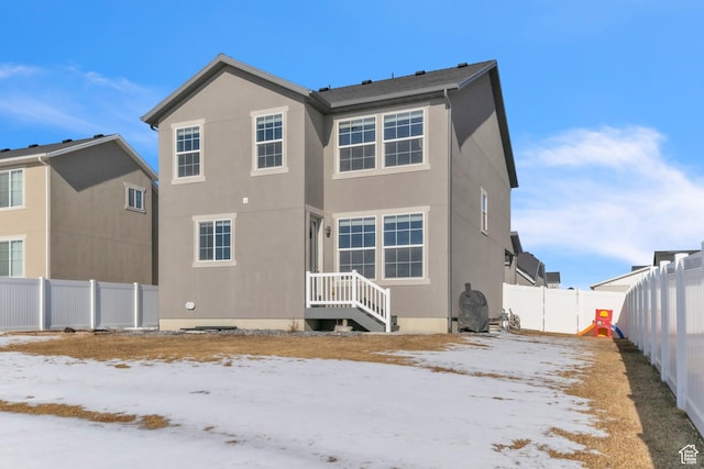 view of snow covered rear of property