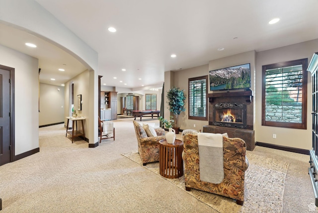 3180 E Stoney Creek Cir S, Heber City, UT 84032 - carpeted living room featuring baseboards, arched walkways, a warm lit fireplace, recessed lighting, and healthy amount of natural light