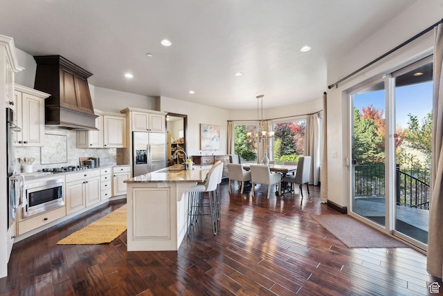 3180 E Stoney Creek Cir S, Heber City, UT 84032 - kitchen featuring appliances with stainless steel finishes, light stone countertops, a chandelier, an island with sink, and dark wood-style floors