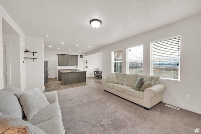 1054 S 1050 W, Tooele, UT 84074 - living room featuring light colored carpet, baseboards, and recessed lighting