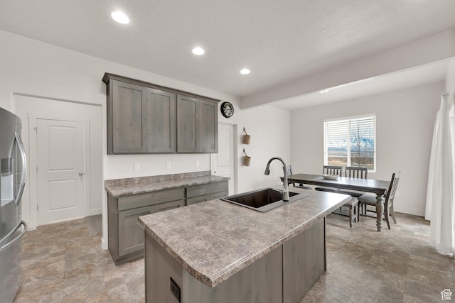 1054 S 1050 W, Tooele, UT 84074 - kitchen with stainless steel fridge, a sink, recessed lighting, a kitchen island with sink, and baseboards