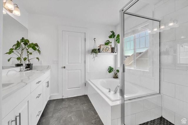 bathroom featuring double vanity, a bath, a stall shower, and a sink
