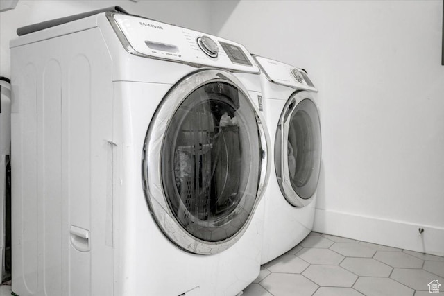 clothes washing area with washing machine and clothes dryer, laundry area, and light tile patterned flooring