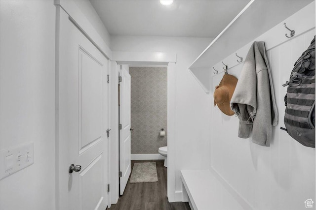 mudroom with wallpapered walls, baseboards, and dark wood-style flooring