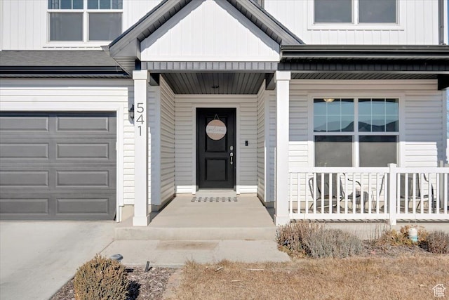 view of exterior entry with board and batten siding and a porch