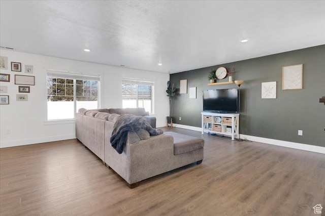 living room featuring recessed lighting, wood finished floors, and baseboards