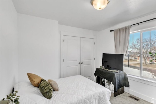 bedroom featuring a closet, visible vents, baseboards, and carpet floors