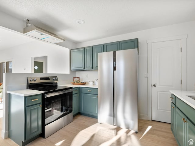 kitchen with stainless steel appliances, light hardwood / wood-style floors, and a textured ceiling