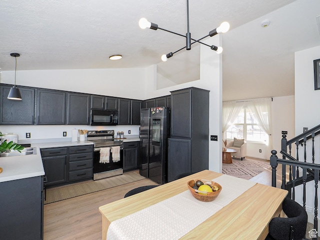 kitchen with pendant lighting, refrigerator, sink, electric range, and light wood-type flooring