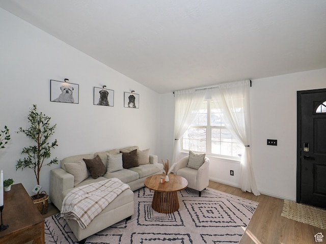 living room with lofted ceiling and light hardwood / wood-style flooring
