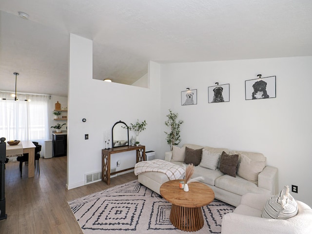 living room featuring lofted ceiling and hardwood / wood-style floors