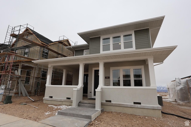 view of front of home featuring covered porch and stucco siding