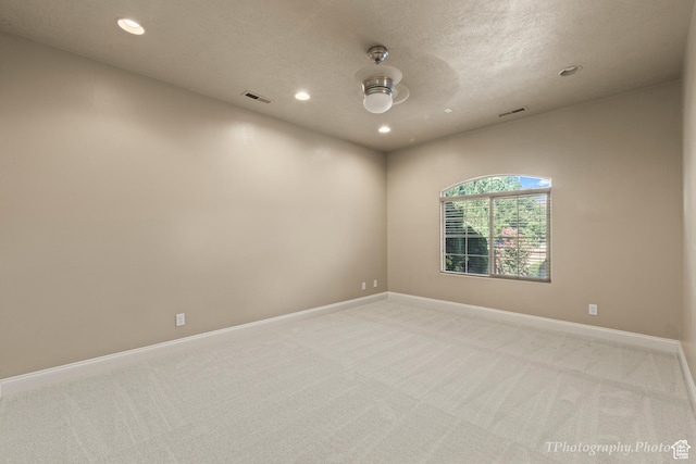 carpeted empty room with a textured ceiling and ceiling fan